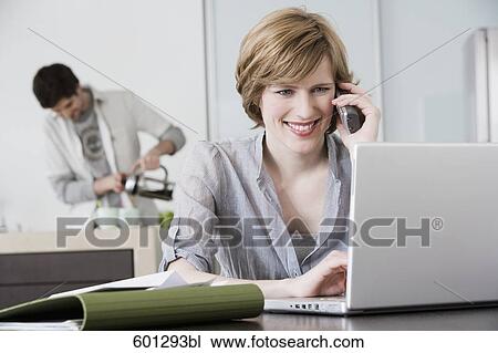 portrait of woman working from home with man making coffee View Large Photo Image Stock Image - portrait of woman working from home with man making coffee. Fotosearch