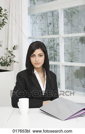 portrait of young businesswoman sitting at desk View Large Photo Image Stock Image - portrait of young businesswoman sitting at desk. Fotosearch
