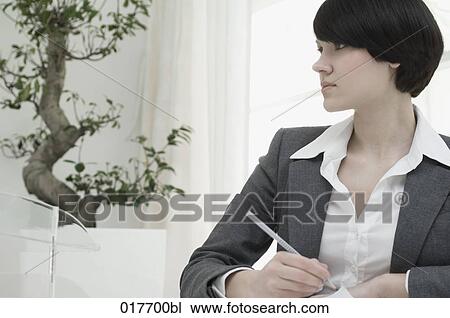 portrait of young businesswoman sitting at desk taking notes View Large Photo Image Stock Image - portrait of young businesswoman sitting at desk taking notes. Fotosearch