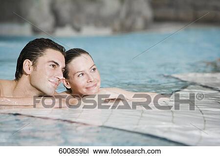 Stock Image - portrait of young couple in swimming pool. Fotosearch