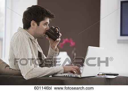 portrait of young man at home working with laptop computer and drink coffee View Large Photo Image Stock Image - portrait of young man at home working with laptop computer and drink coffee. Fotosearch