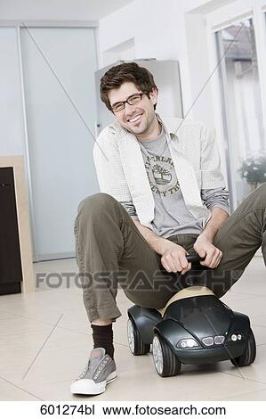 portrait of young man driving toy car at home View Large Photo Image Stock Image - portrait of young man driving toy car at home. Fotosearch