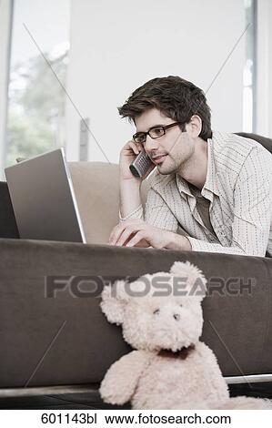 portrait of young man working at home with laptop computer and talking on telephone View Large Photo Image Stock Image - portrait of young man working at home with laptop computer and talking on telephone. Fotosearch