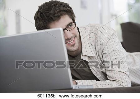 portrait of young man working with laptop computer at home View Large Photo Image Stock Image - portrait of young man working with laptop computer at home. Fotosearch