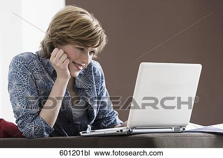 portrait of young woman at home working with laptop computer View Large Photo Image Stock Image - portrait of young woman at home working with laptop computer. Fotosearch