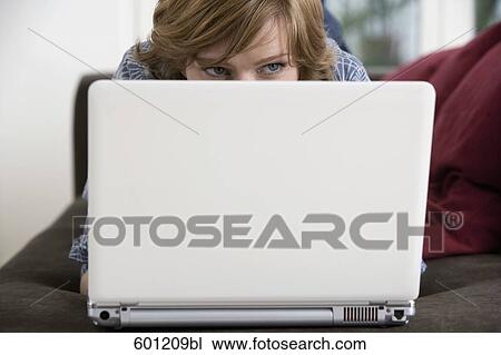 portrait of young woman hiding behind laptop computer View Large Photo Image Stock Image - portrait of young woman hiding behind laptop computer. Fotosearch