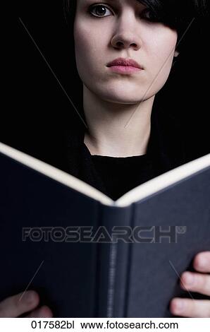 Stock Image - portrait of young woman reading book. Fotosearch