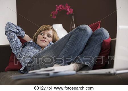 portrait of young woman relaxing on sofa View Large Photo Image Stock Image - portrait of young woman relaxing on sofa. Fotosearch