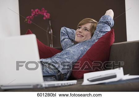 portrait of young woman relaxing on sofa View Large Photo Image Stock Image - portrait of young woman relaxing on sofa. Fotosearch