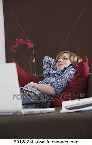 portrait of young woman relaxing on sofa View Large Photo Image Stock Image - portrait of young woman relaxing on sofa. Fotosearch