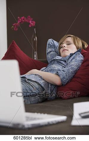 portrait of young woman relaxing on sofa View Large Photo Image Stock Image - portrait of young woman relaxing on sofa. Fotosearch