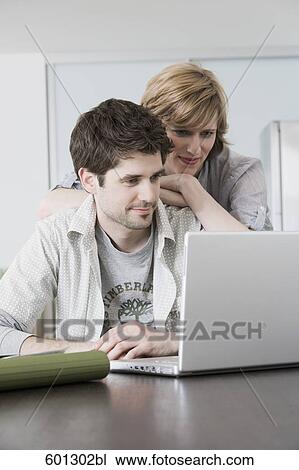 portrait sitting at home looking at laptop computer View Large Photo Image Stock Image - portrait sitting at home looking at laptop computer. Fotosearch