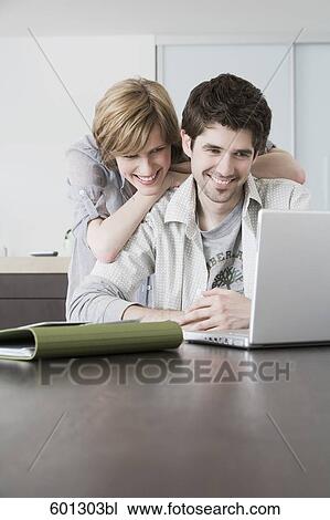 portrait sitting at home looking at laptop computer View Large Photo Image Stock Image - portrait sitting at home looking at laptop computer. Fotosearch