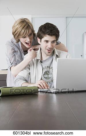 portrait sitting at home looking at laptop computer View Large Photo Image Stock Image - portrait sitting at home looking at laptop computer. Fotosearch