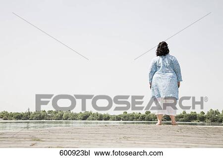 rear view view of overweight woman standing on pier by lake View Large Photo Image Stock Image - rear view view of overweight woman standing on pier by lake. Fotosearch