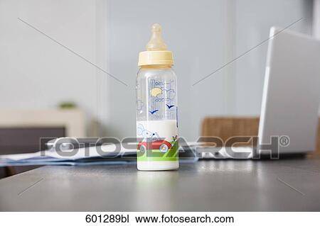 still life of baby bottle on table with laptop computer in background View Large Photo Image Stock Image - still life of baby bottle on table with laptop computer in background. Fotosearch
