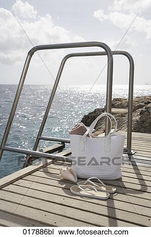 still life of bag and flip flops on pier View Large Photo Image Stock Image - still life of bag and flip flops on pier. Fotosearch