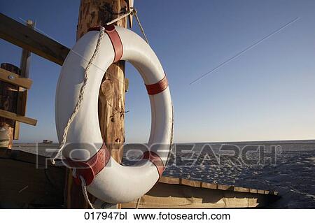 Stock Image - still life of life buoy on beach. Fotosearch