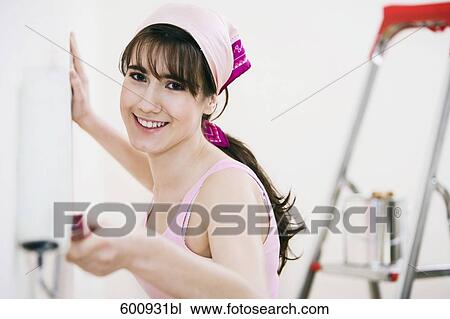 Stock Image - teenage girl decorating walls of her new home. Fotosearch
