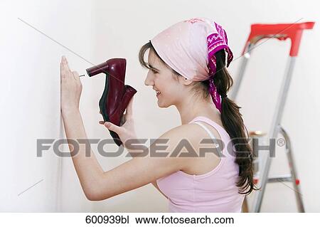 tennage girl doing decoration work using shoe as hammer View Large Photo Image Stock Image - tennage girl doing decoration work using shoe as hammer. Fotosearch