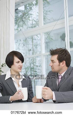 two business people sitting at table having break View Large Photo Image Stock Image - two business people sitting at table having break. Fotosearch