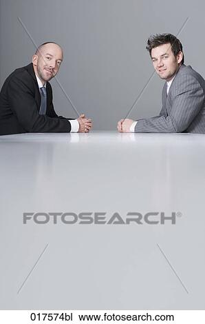 two businessmen sitting at conference table View Large Photo Image Stock Image - two businessmen sitting at conference table. Fotosearch