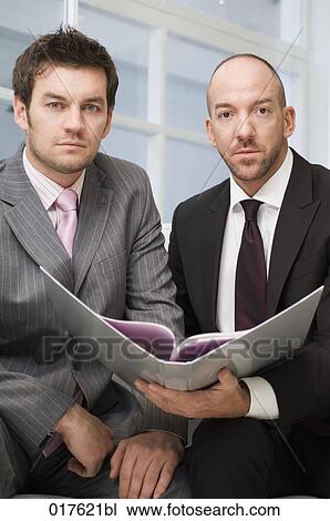 two businessmen sitting together reading document View Large Photo Image Stock Image - two businessmen sitting together reading document. Fotosearch