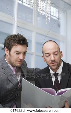 two businessmen sitting together reading document View Large Photo Image Stock Image - two businessmen sitting together reading document. Fotosearch