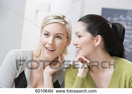 two female friends at restaurant whispering to each other View Large Photo Image Stock Image - two female friends at restaurant whispering to each other. Fotosearch