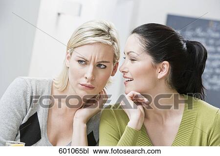 two female friends at restaurant whispering to each other View Large Photo Image Stock Image - two female friends at restaurant whispering to each other. Fotosearch