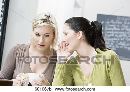 two female friends at restaurant whispering to each other View Large Photo Image Stock Image - two female friends at restaurant whispering to each other. Fotosearch