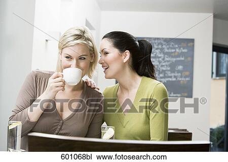 two female friends at restaurant whispering to each other View Large Photo Image Stock Image - two female friends at restaurant whispering to each other. Fotosearch