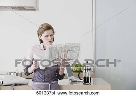 woman at morning standing in kitchen drinking coffee and reading newspaper View Large Photo Image Stock Image - woman at morning standing in kitchen drinking coffee and reading newspaper. Fotosearch