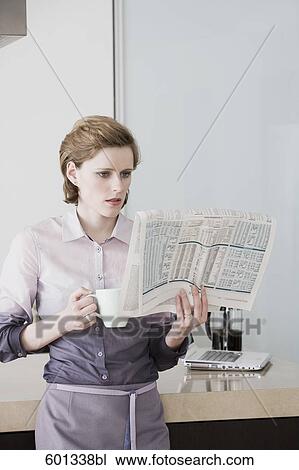 woman at morning standing in kitchen drinking coffee and reading newspaper View Large Photo Image Stock Image - woman at morning standing in kitchen drinking coffee and reading newspaper. Fotosearch