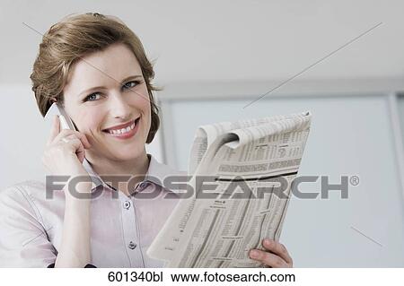woman reading newspaper and talking on mobile phone View Large Photo Image Stock Image - woman reading newspaper and talking on mobile phone. Fotosearch