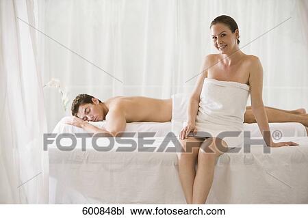 woman sitting on massage bench with man lying in background View Large Photo Image Stock Image - woman sitting on massage bench with man lying in background. Fotosearch