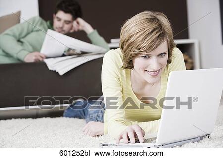 woman working with laptop computer at home while man is reading newspaper View Large Photo Image Stock Image - woman working with laptop computer at home while man is reading newspaper. Fotosearch