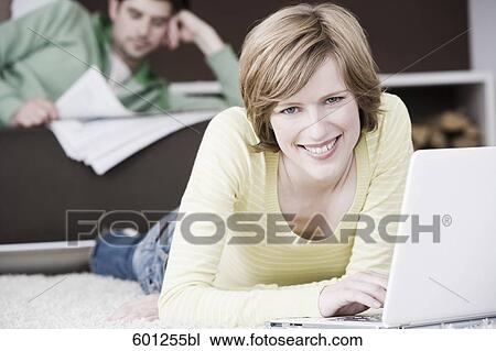 woman working with laptop computer at home while man is reading newspaper View Large Photo Image Stock Image - woman working with laptop computer at home while man is reading newspaper. Fotosearch