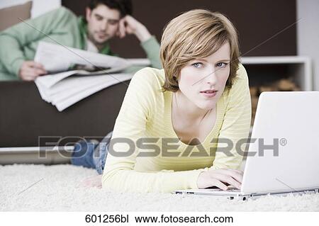 woman working with laptop computer at home while man is reading newspaper View Large Photo Image Stock Image - woman working with laptop computer at home while man is reading newspaper. Fotosearch