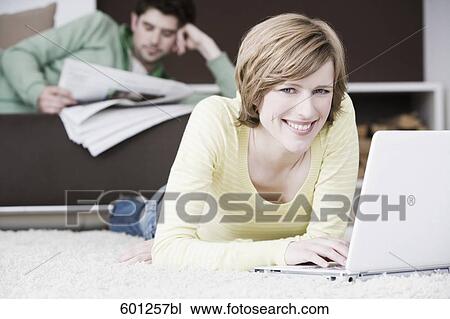 woman working with laptop computer at home while man is reading newspaper View Large Photo Image Stock Image - woman working with laptop computer at home while man is reading newspaper. Fotosearch