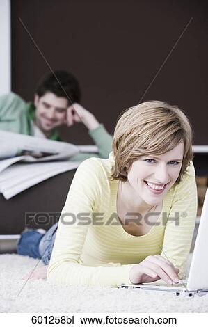 woman working with laptop computer at home while man is reading newspaper View Large Photo Image Stock Image - woman working with laptop computer at home while man is reading newspaper. Fotosearch
