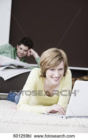 woman working with laptop computer at home while man is reading newspaper View Large Photo Image Stock Image - woman working with laptop computer at home while man is reading newspaper. Fotosearch