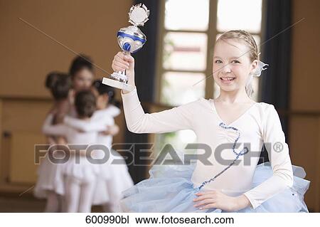 young ballet dancer in front of group holding trophy View Large Photo Image Stock Image - young ballet dancer in front of group holding trophy. Fotosearch