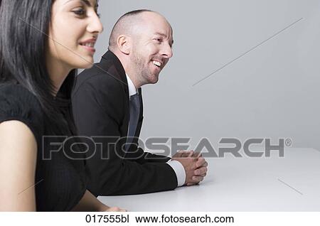 young businesswoman sitting at conference table with male colleague View Large Photo Image Stock Image - young businesswoman sitting at conference table with male colleague. Fotosearch