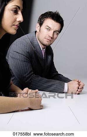 young businesswoman sitting at conference table with male colleague View Large Photo Image Stock Image - young businesswoman sitting at conference table with male colleague. Fotosearch