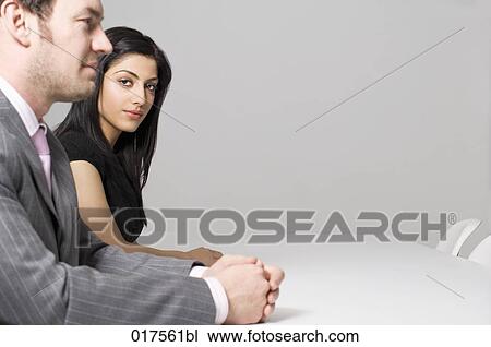 young businesswoman sitting at conference table with male colleague View Large Photo Image Stock Image - young businesswoman sitting at conference table with male colleague. Fotosearch