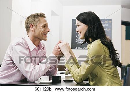 Stock Image - young couple at cafe flirting with each other. Fotosearch