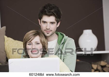 young couple at home working with laptop computer together View Large Photo Image Stock Image - young couple at home working with laptop computer together. Fotosearch