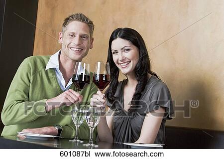young couple at restaurant raising their glasses View Large Photo Image Stock Image - young couple at restaurant raising their glasses. Fotosearch
