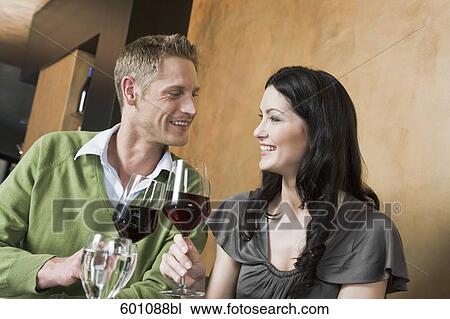 young couple at restaurant raising their glasses View Large Photo Image Stock Image - young couple at restaurant raising their glasses. Fotosearch